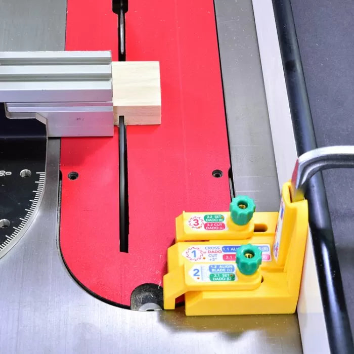 Woodworking table saw with miter gauge, stop block, and yellow dado setup jig in use