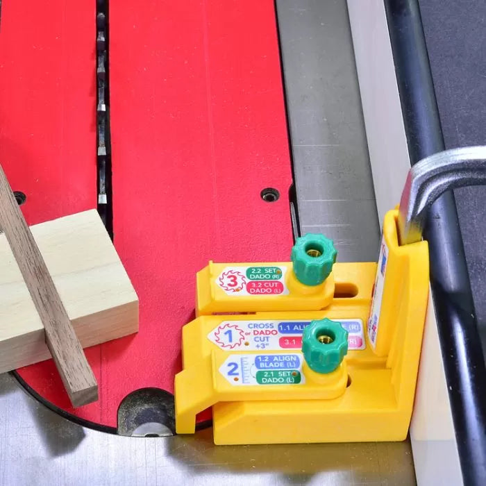 Table saw with dado blade setup jig, yellow alignment tool, and wood block for woodworking