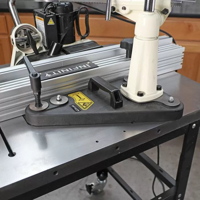 Woodworking router table setup with fence, hold-down clamp, and tool support arm