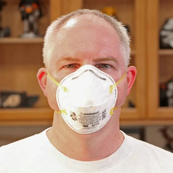 Man wearing N95 dust mask in woodworking shop for safety and respiratory protection