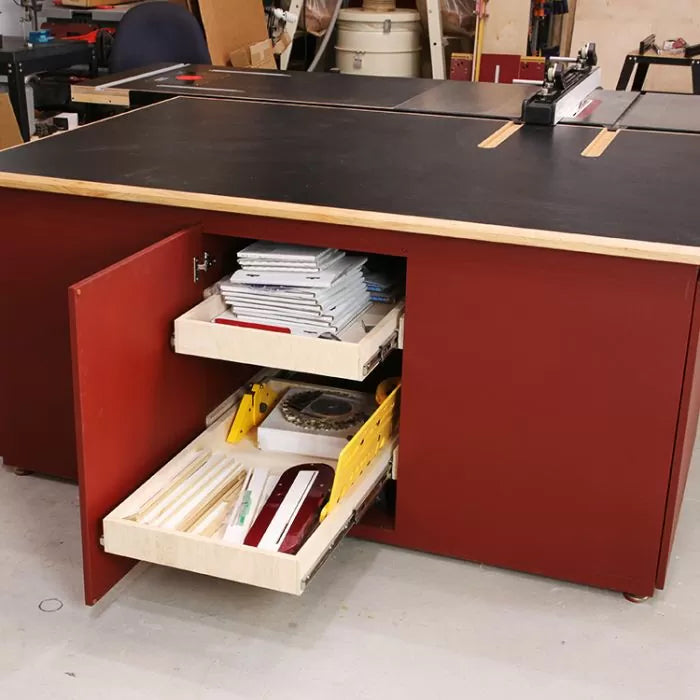 Woodworking shop table saw station with open storage drawers holding tools and accessories