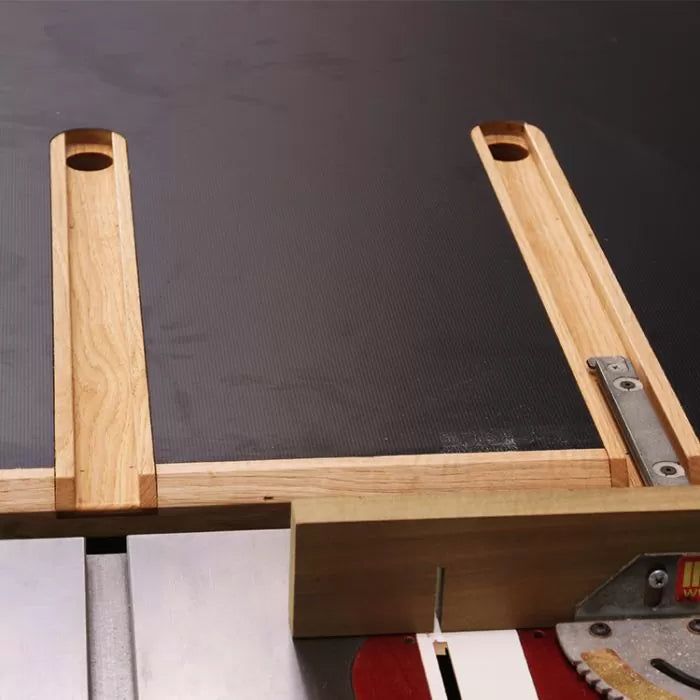 Woodworking crosscut sled on a table saw with exposed saw blade and wooden handles