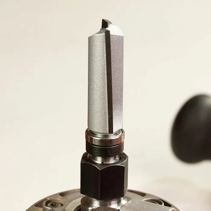 Close-up of a straight carbide router bit installed in a router, woodworking tool detail