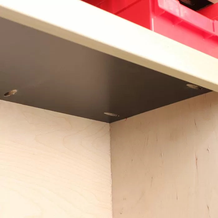 Close-up of woodworking jig with drilled pocket holes on a cabinet shelf