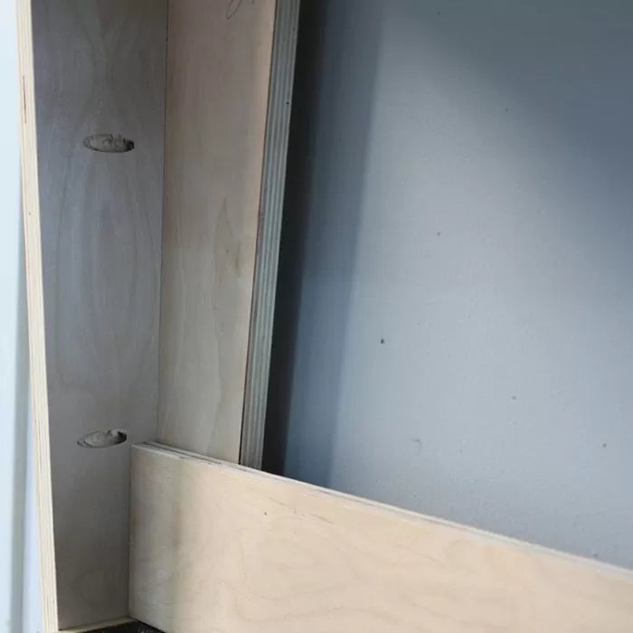 Close-up of plywood cabinet joint with pocket holes for woodworking assembly