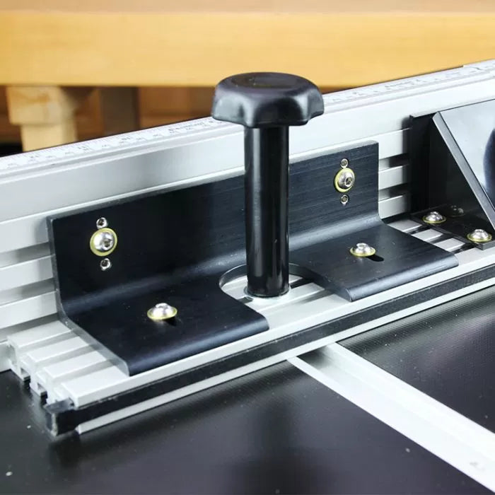 Close-up of router table fence with safety guard and adjustment knob for woodworking