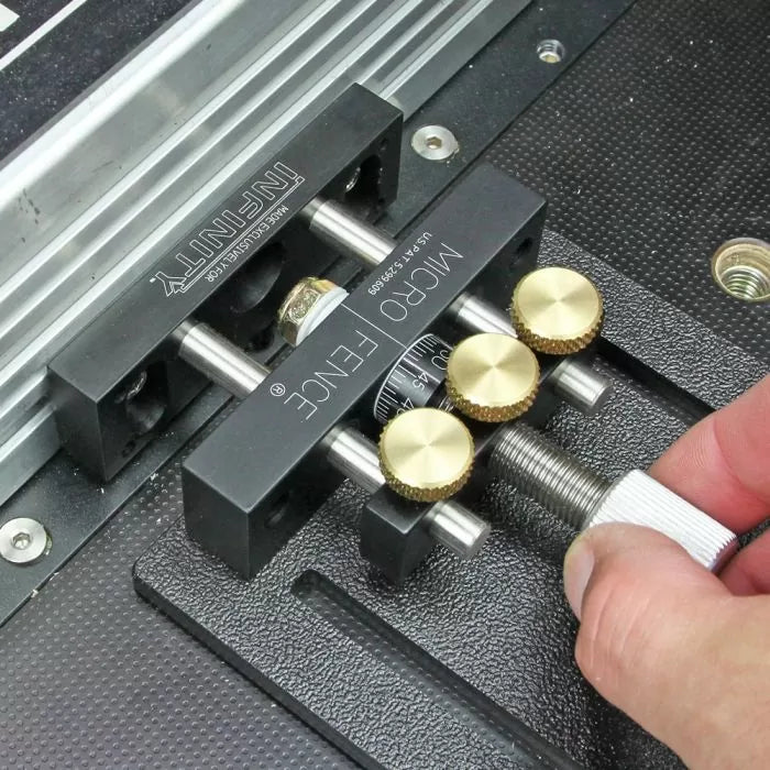 Close-up of a router table micro fence adjustment tool with brass knobs and precision scale.