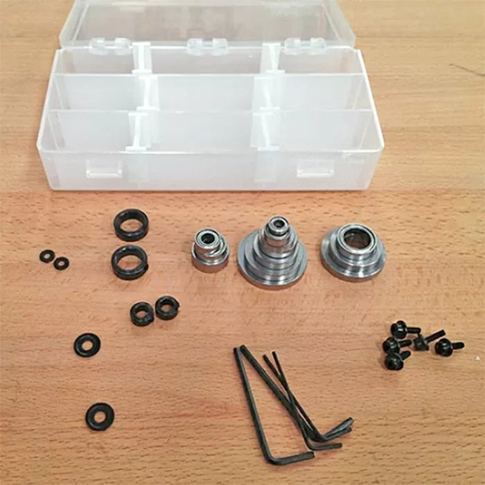 Router bit bearing kit with bushings, screws, hex keys, and plastic storage case on wood surface