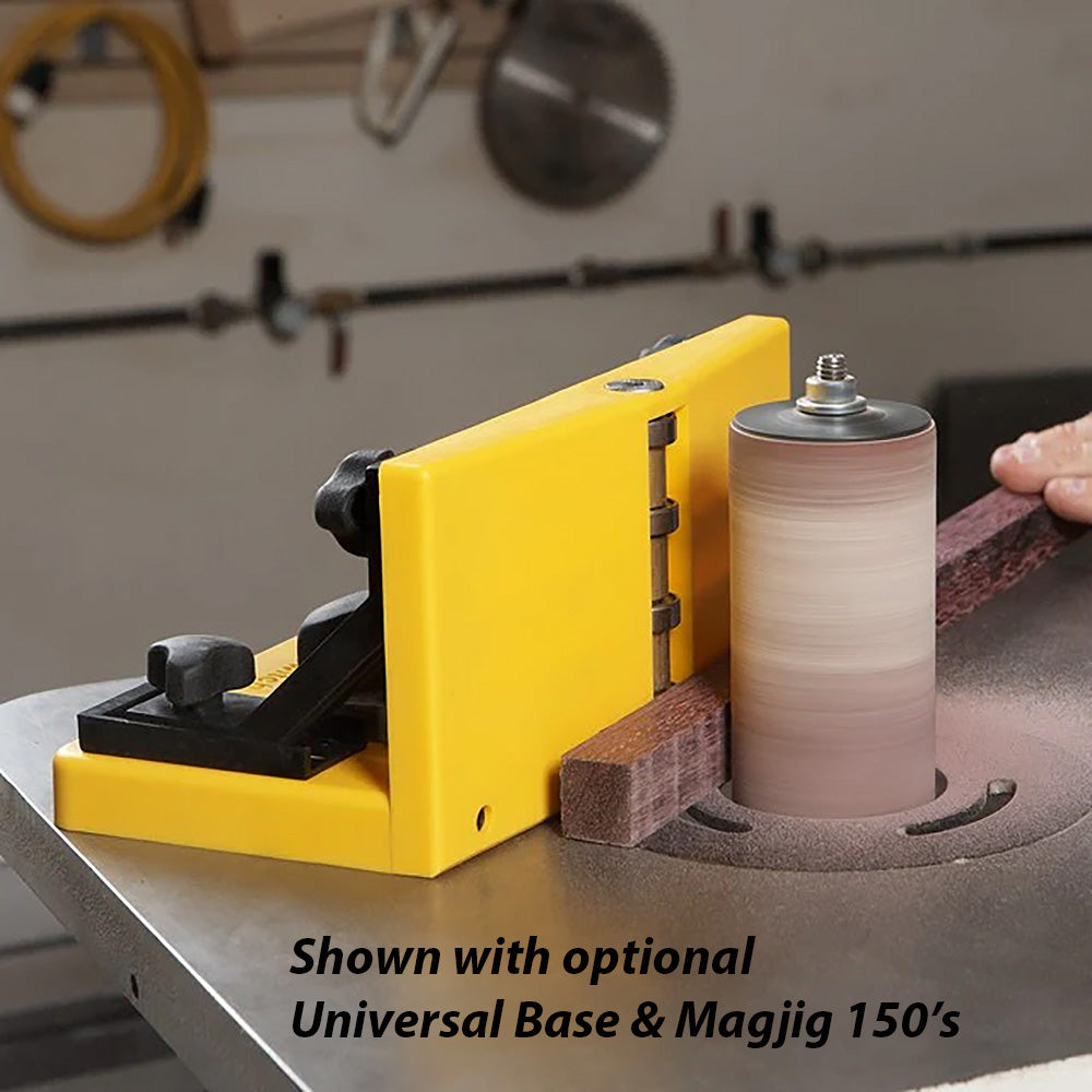 Oscillating spindle sander with yellow fence and wood being sanded in a woodworking shop