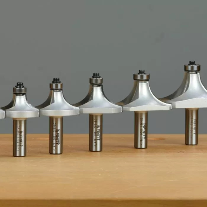 Set of roundover router bits with ball bearings on wooden surface, woodworking tools