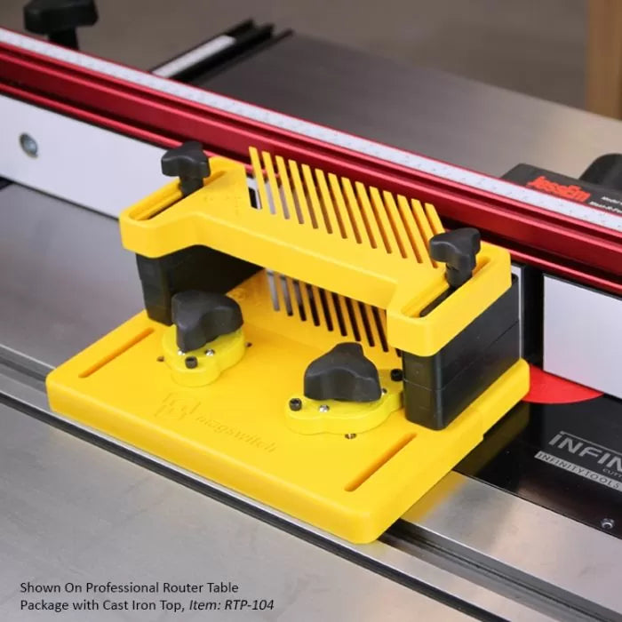 Yellow featherboard mounted on router table fence for woodworking precision and safety.