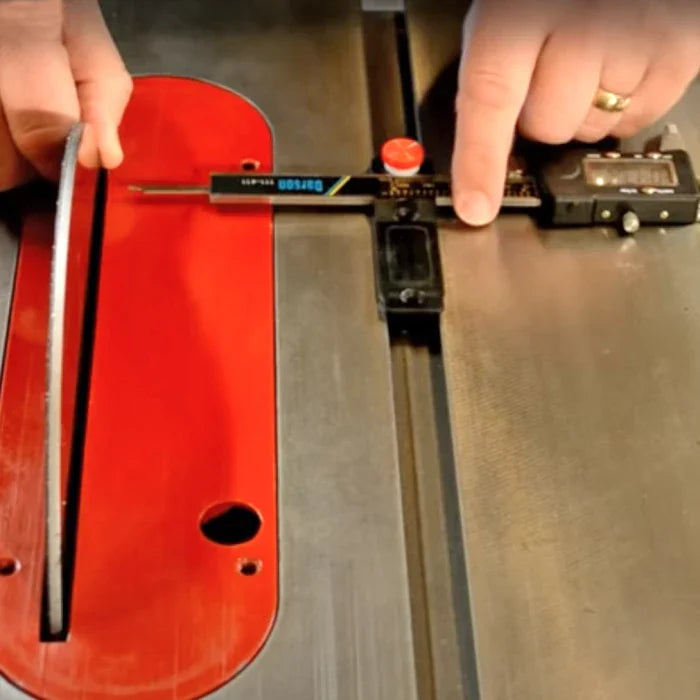 Measuring table saw blade alignment with digital caliper on metal surface