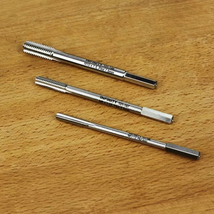 Set of three metal threading taps for woodworking or metalworking on a wood surface