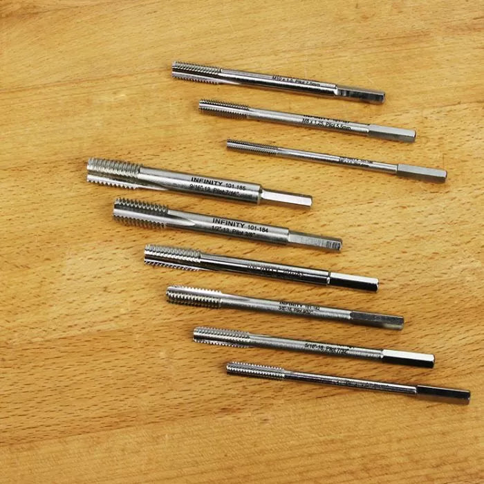 Set of metal threading taps for woodworking on a wooden surface