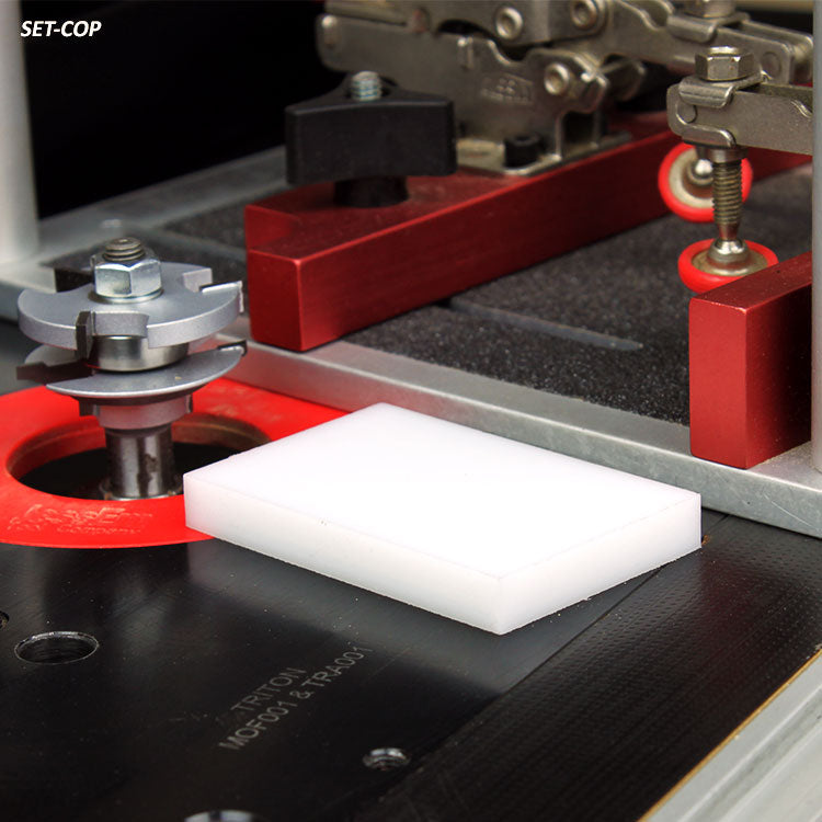 Router table setup with router bit, push block, and clamp for woodworking precision