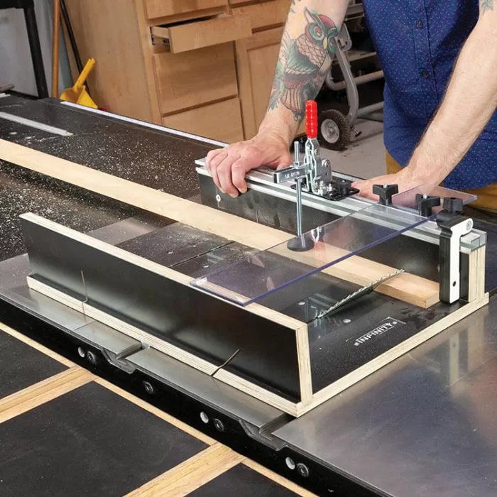 Woodworker using table saw crosscut sled jig to cut lumber in workshop