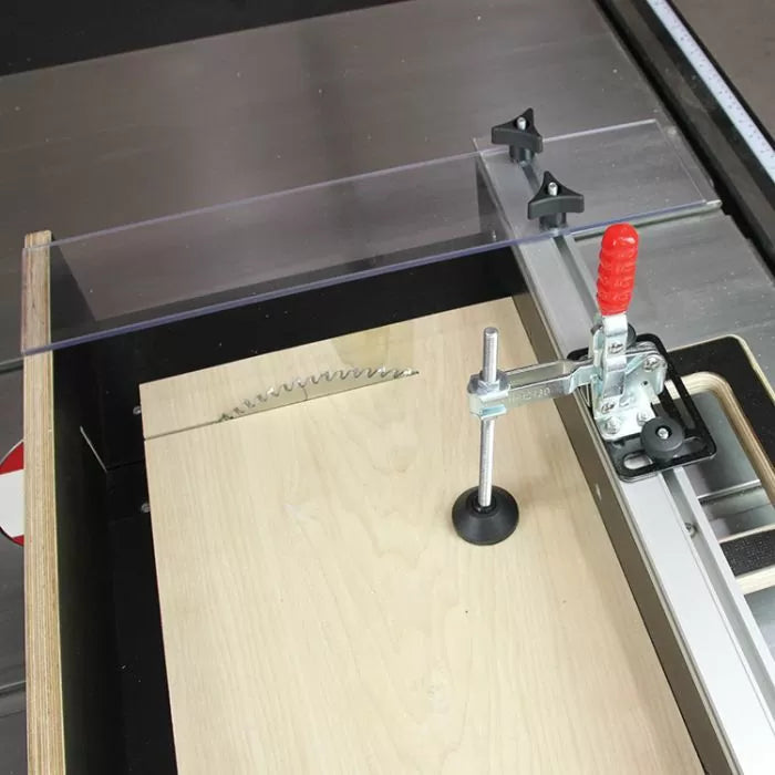 Table saw crosscut sled with hold-down clamp, blade guard, and wood panel setup