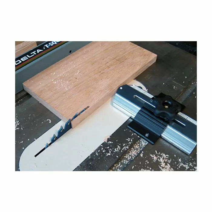 Table saw crosscut sled guide with wooden board on saw blade for precise woodworking cuts