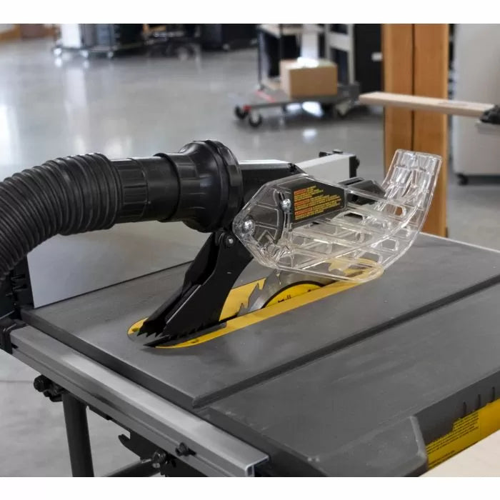 Table saw with dust collection hose and clear blade guard in a woodworking shop