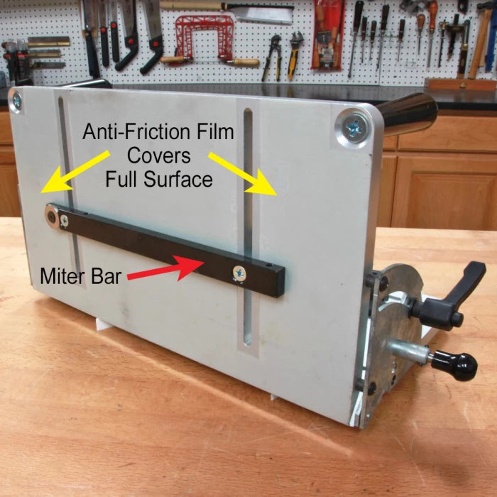 Miter bar and anti-friction slick tape attached to woodworking jig on workbench