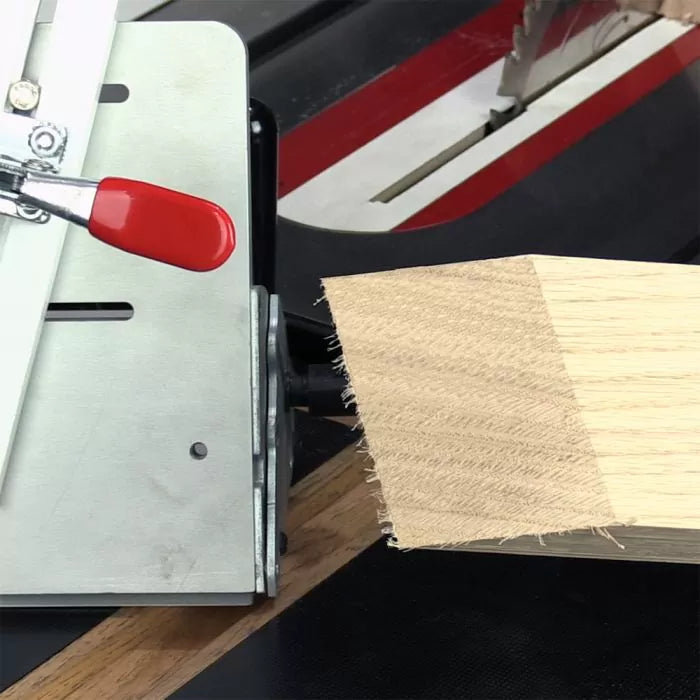 Table saw cutting jig with red handle holding wood block for precise angled cuts