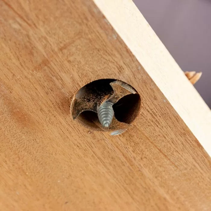 Close-up of a clean wood countersink hole with an exposed screw, woodworking detail