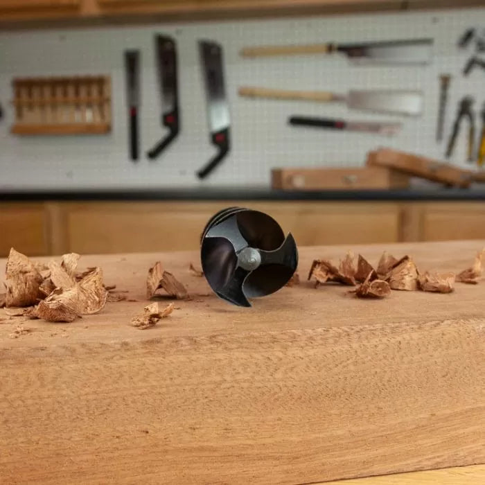 Wood drill bit close-up on workbench with wood shavings in woodworking shop