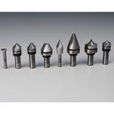Assorted woodworking router bits set on gray surface, precision cutting tools for wood.