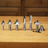Woodworking router bit set with assorted profiles and accessories on a wooden table
