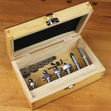 Woodworking router bit set with bearings in an open wooden storage box on a workbench
