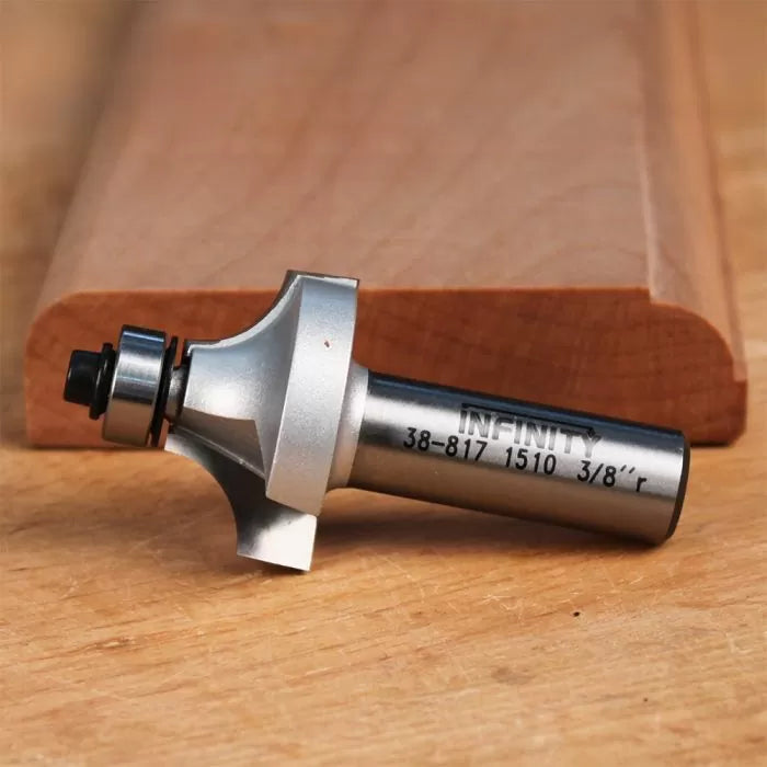 Roundover router bit with bearing tip shown beside edge-profiled wood on a workbench