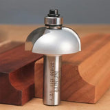 Roundover router bit for woodworking, shown with shaped wooden boards on a workbench.