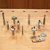 Assorted woodworking router bits, bearings, and tools arranged on a workshop bench