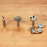 Woodworking router bits and bearings set on a wooden workbench