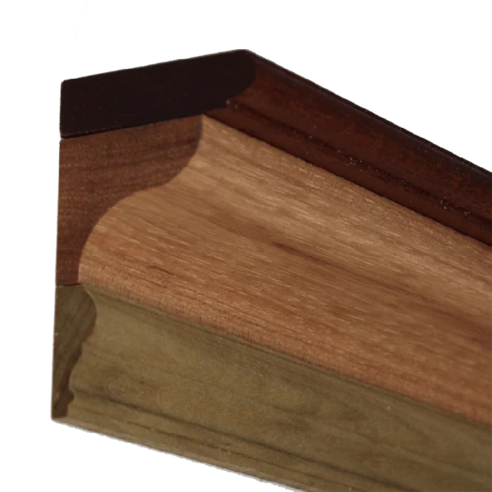 Close-up of a wooden crown molding joint with detailed routed edge profile.