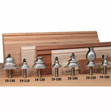 Assorted woodworking router bits with sample wood moldings and part numbers displayed