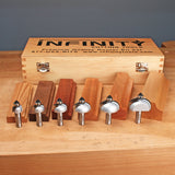 Wooden box with six roundover router bits and wood molding samples on a workbench