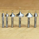 Set of six metal router bits for woodworking on a wooden surface