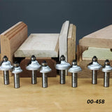 Set of woodworking router bits displayed on a workbench with shaped wood samples