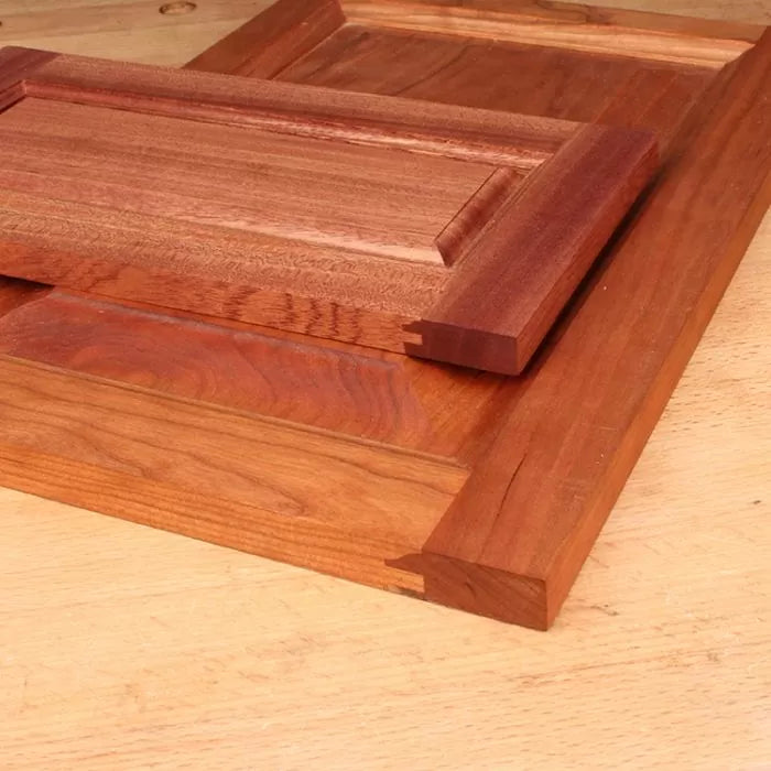 Close-up of hardwood cabinet door panels with box joint joinery on a wooden workbench