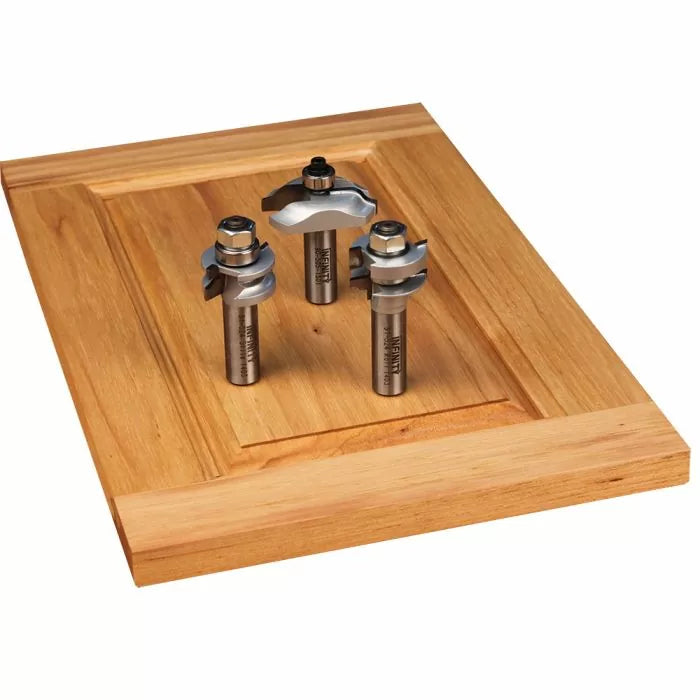 Three woodworking router bits on a wooden cabinet door panel