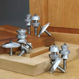Assorted woodworking router bits displayed on wooden boards for joinery and edge shaping.