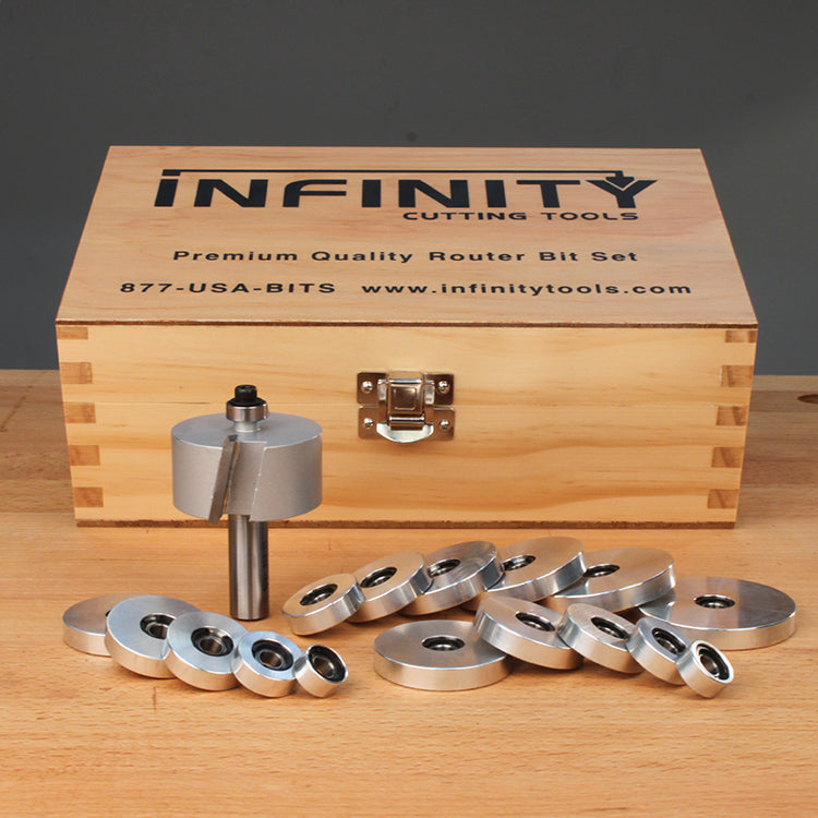 Router bit set with assorted bearings on a workbench in front of a wooden storage box.