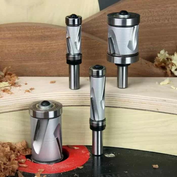 Carbide spiral router bits for woodworking displayed with wood shavings on a workbench.