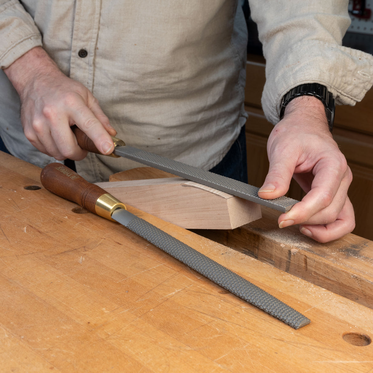 Person shaping wood with a premium rasp file on a woodworking bench