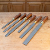 Six-piece premium woodworking rasp set with wooden handles on a workbench