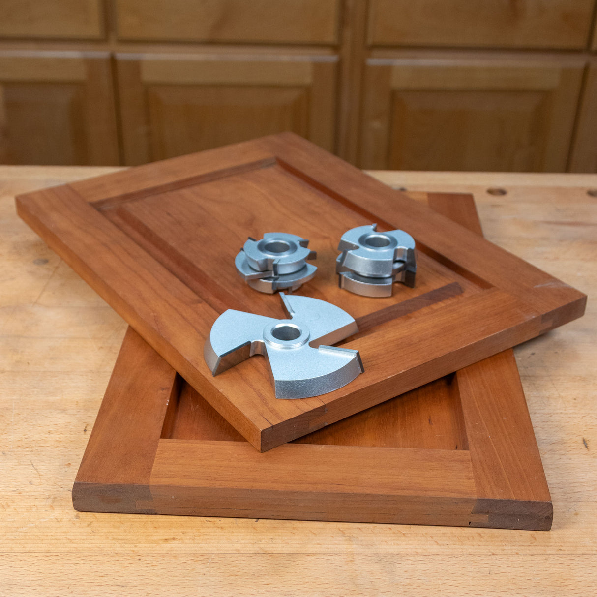 Shaker cabinet door set with three-piece shaper cutter set on a wooden workbench