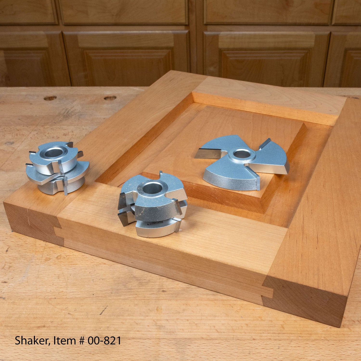 Shaker door router bit set on a wooden panel, woodworking tools on workbench.
