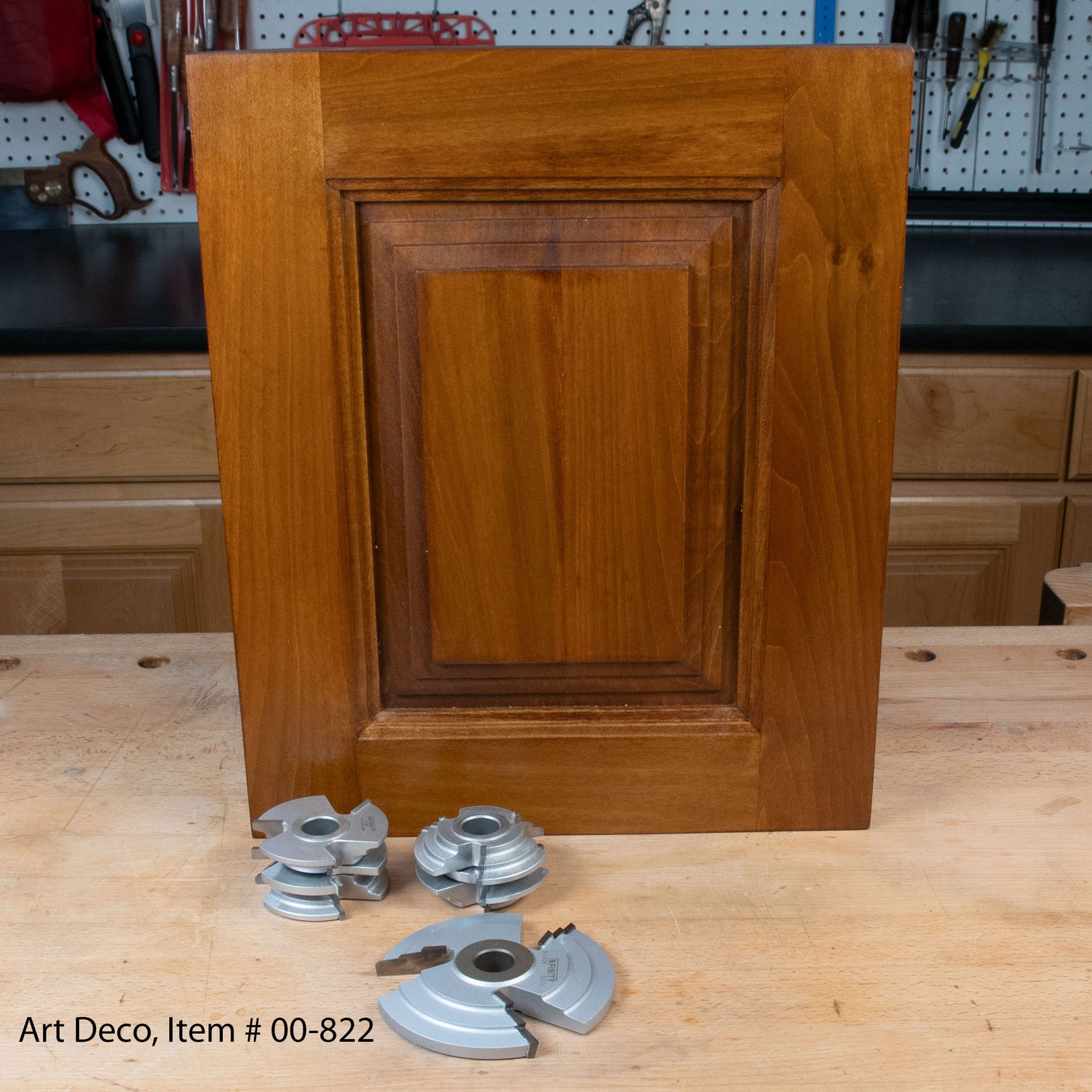 Art Deco cabinet door panel with three metal router shaper cutters on a woodworking bench