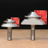 Two large chamfer router bits with red setup blocks on a wooden surface, ideal for woodworking.